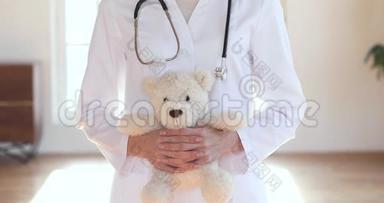快乐女医生儿科医生拿着泰迪熊看相机